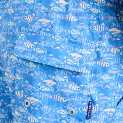 Blue Peter Millar swim trunks featuring a playful fish print, back pocket, and branded tag on quick-dry stretch fabric.