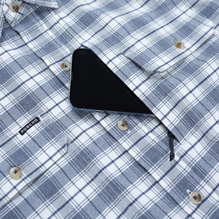 Blue and white plaid performance flannel shirt featuring a magnetic chest pocket holding a smartphone and a Poncho logo tag.