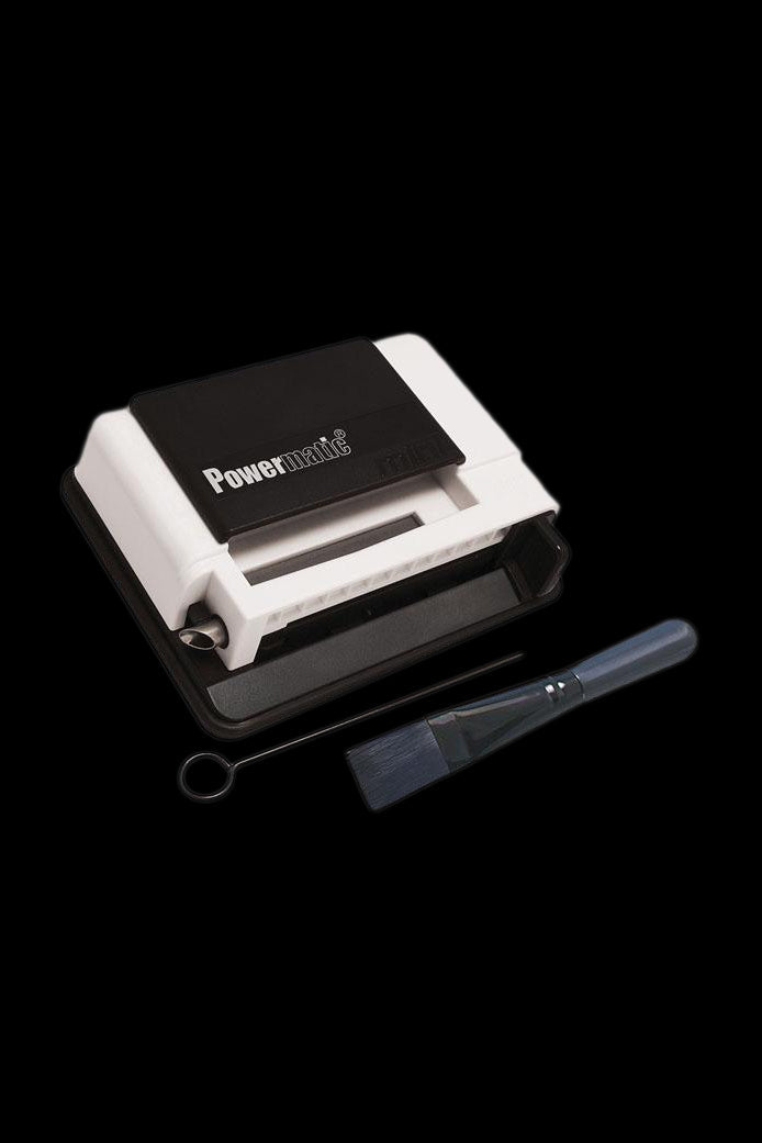 Powermatic cigarette rolling machine with cleaning brush.