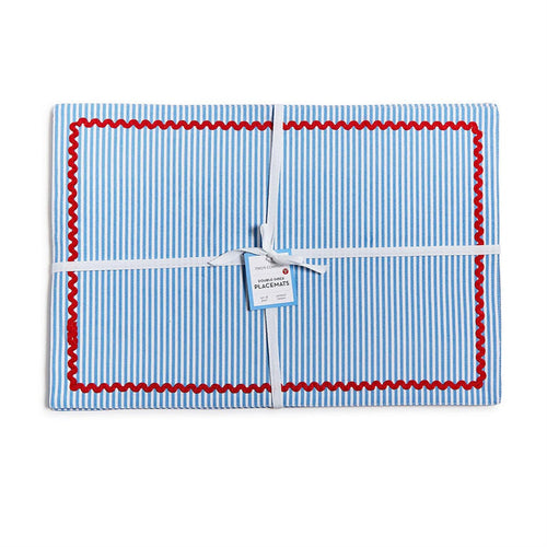 Set of 4 blue and white striped cotton placemats with red rickrack trim, tied with a white ribbon.