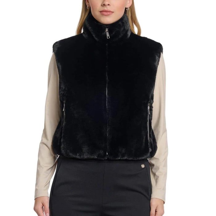 Model wearing a black Rino & Pelle short faux fur waistcoat with a high collar, zipper closure, and side pockets.