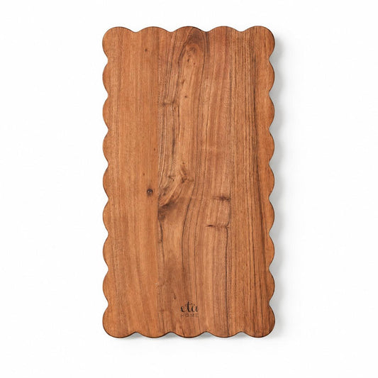 Rectangle acacia wood cutting board with elegant scalloped edges and visible natural wood grain.