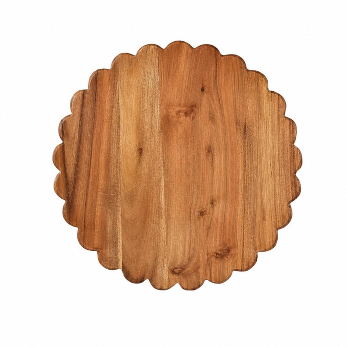 Round acacia wood cutting board with a decorative scalloped edge and natural wood grain finish.