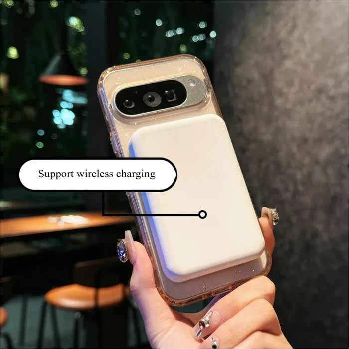 Smartphone in a glittery case with a white wireless charging pad.