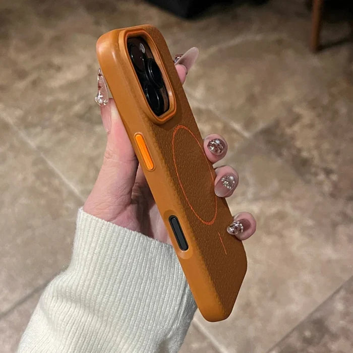 An orange iPhone case with a magnetic charging ring and contrasting black and orange buttons.