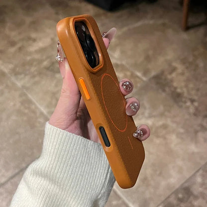 An orange iPhone case with a magnetic charging ring and contrasting black and orange buttons.