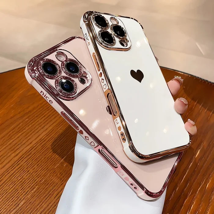 Two rose gold and white iPhone cases with heart designs.