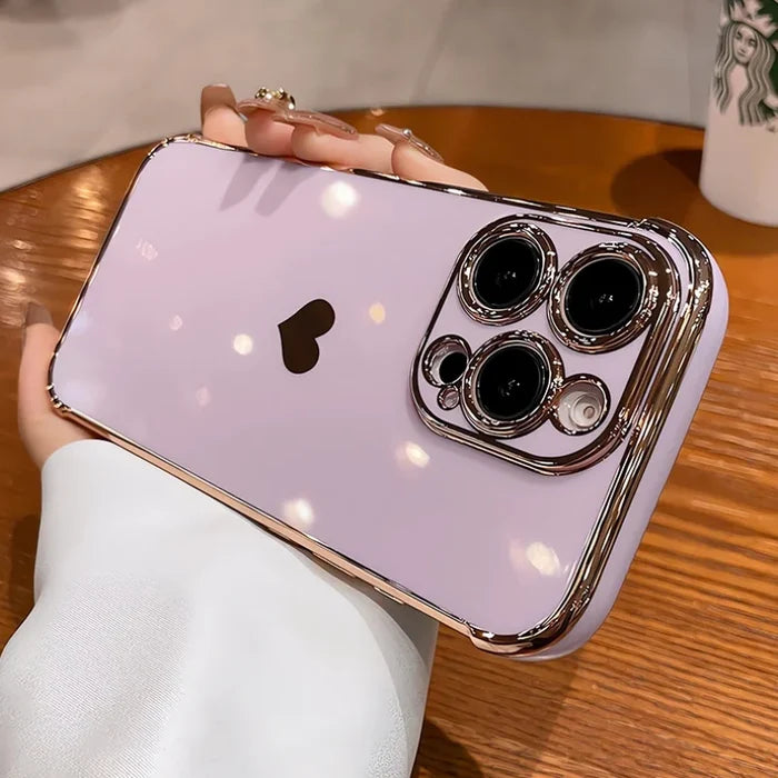 Lavender iPhone with a heart-shaped logo cutout and a gold-edged camera protector.