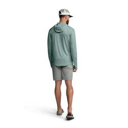 Man wearing a sage green Sitka Guard Sun Hoodie with a hood, paired with grey shorts and a baseball cap.