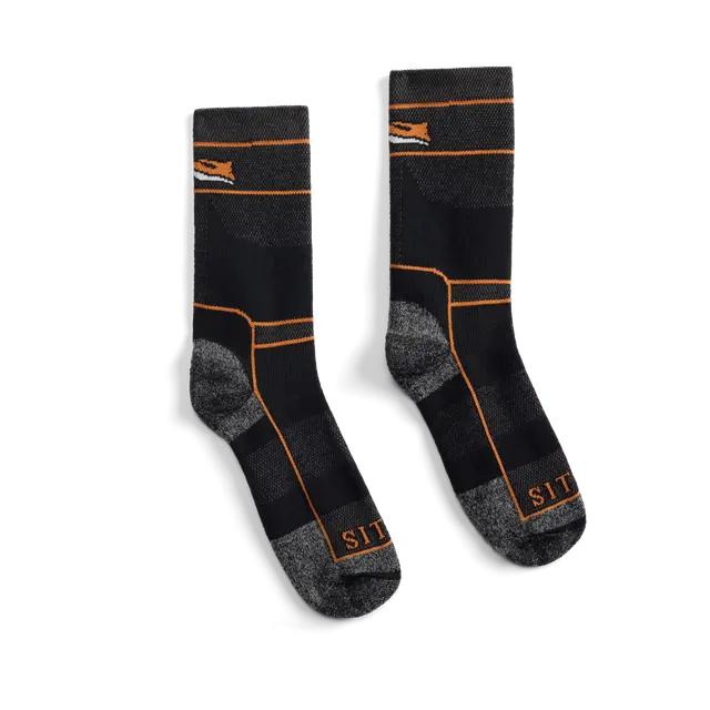 Black and grey Sitka heavy weight crew socks with orange accents, featuring reinforced heels and toes and branded cuffs.