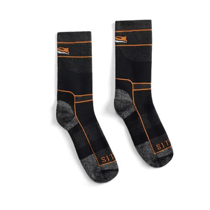Black and grey Sitka heavy weight crew socks with orange accents, featuring reinforced heels and toes and branded cuffs.