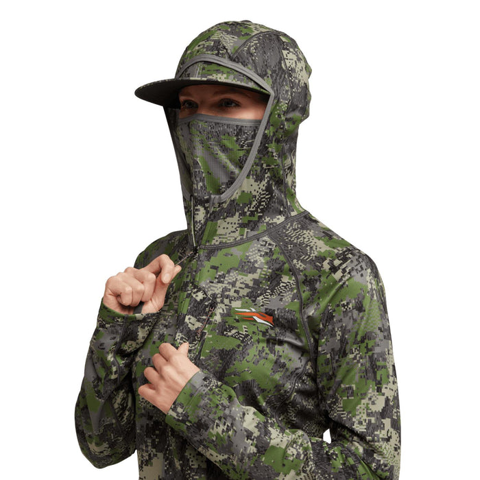 Sitka women's lightweight camo hoodie with built-in hood, mesh facemask, and thumb loops on a white background.