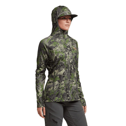 Women wearing a Sitka Core Lightweight Hoodie in green camouflage print with a built-in hood and face mask.