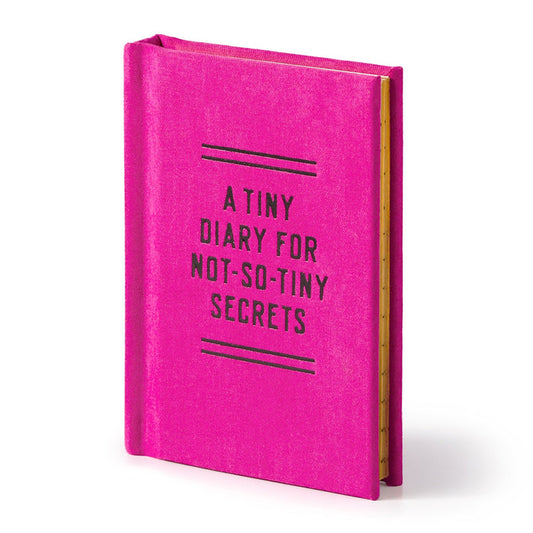 The Brass Monkey Tiny Diary for Not So Tiny Secrets is a small, bright pink hardbound diary with its name in black on the cover and features lined, gold-edged pages inside.