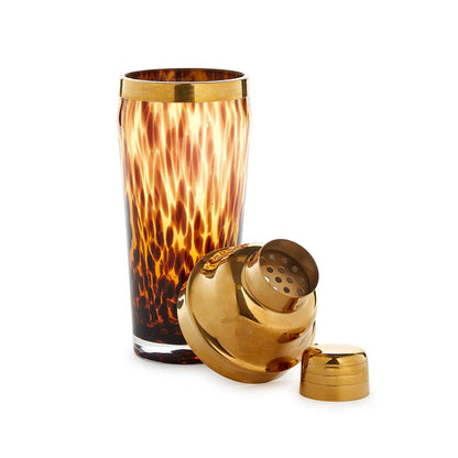 Glass cocktail shaker with a brown tortoise print pattern and polished gold stainless steel lid and strainer.