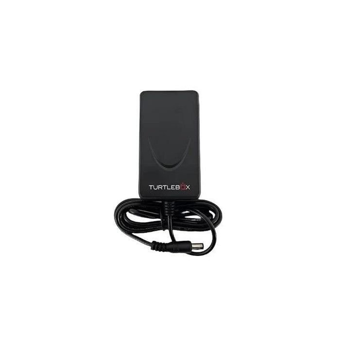 Black Turtlebox co-axial power adapter with a coiled charging cable and barrel connector plug on a white background.
