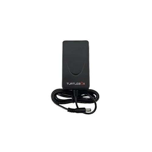 Black Turtlebox co-axial power adapter with a coiled charging cable and barrel connector plug on a white background.