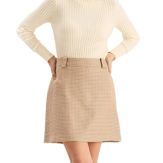 Model wearing a high-waisted, tan houndstooth A-line mini skirt with belt loops and a structured fit.