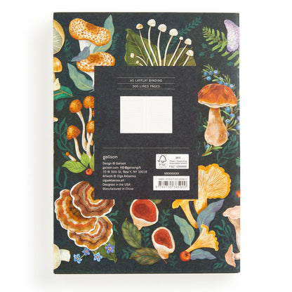 The World of Mushrooms Premium A5 Notebook by Olga Akbarova features a black cover with vibrant mushroom and leaf illustrations, 300 lined pages, and labeled product details—ideal as a botanical journal or mushroom notebook.