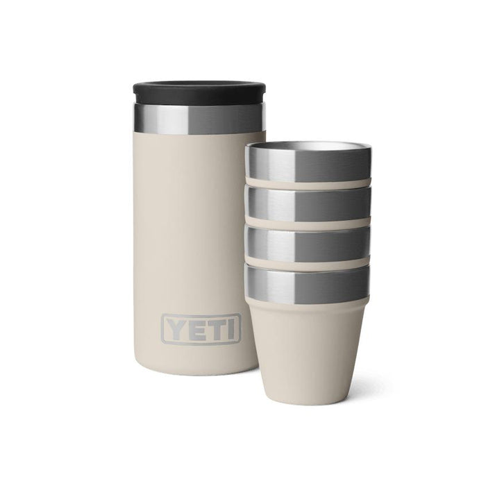 Sand-colored YETI shot glass set with four stackable stainless steel cups and a matching rugged carrying case.