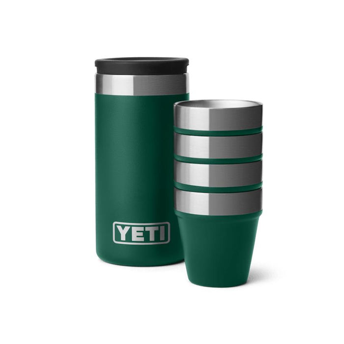 Four stackable green stainless steel YETI shot glasses beside their matching rugged carrying case.